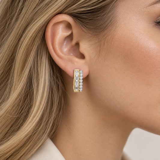 yellow & white gold hoop earrings laid with round & emerald cut diamonds on a blonde haired woman's ear at a side profile angle
